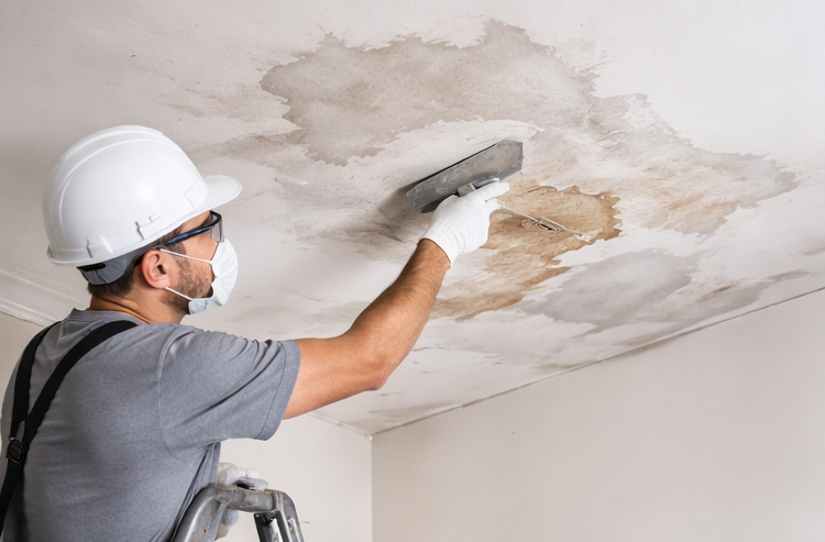 contractor repairing ceiling drywall